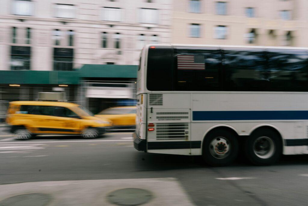 A bus speeding down a street in New York City.