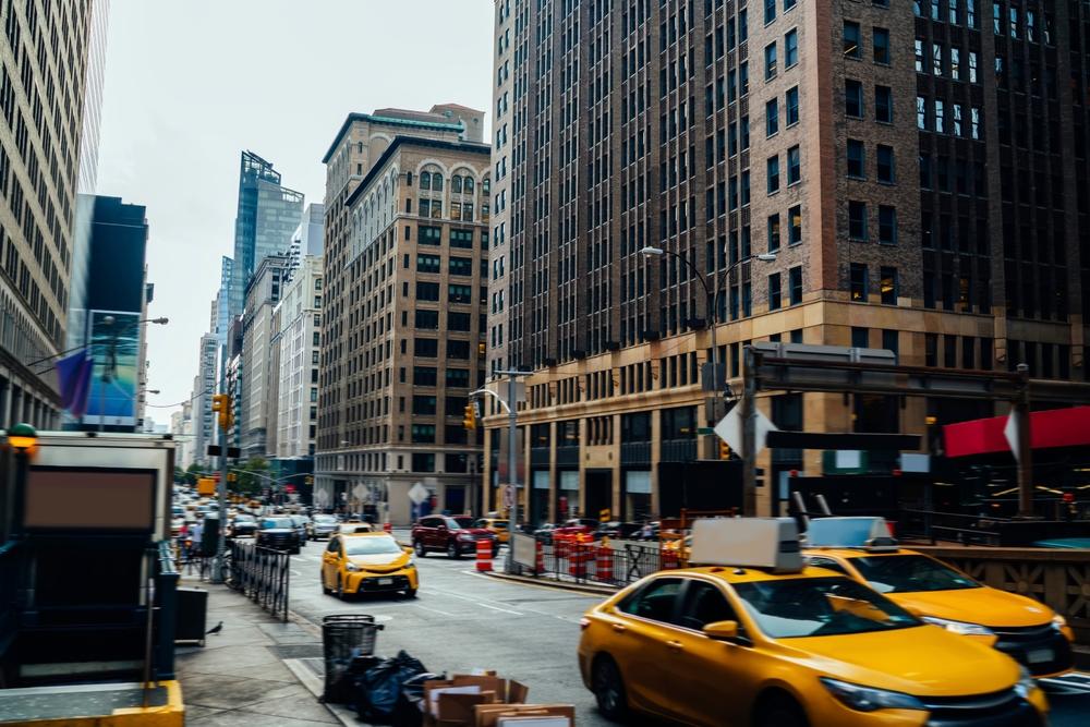Yellow cabs lined up on a busy New York City street, showcasing the iconic urban transportation scene.