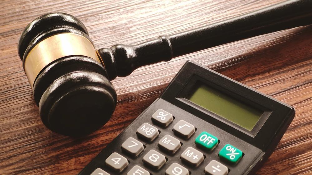 Gavel and a calculator on a wooden desk